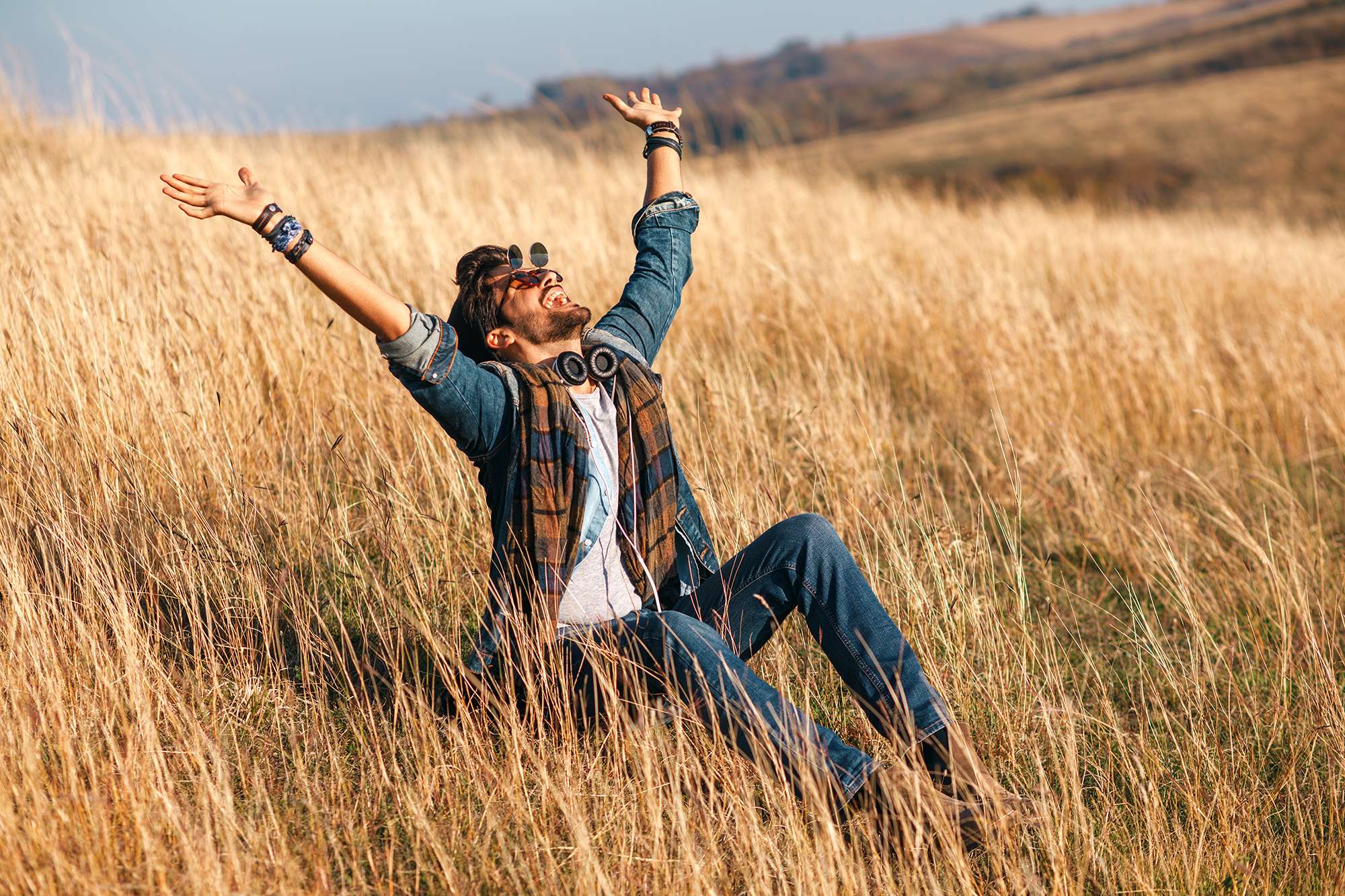 An image of a smiling man sitting in a field of wheat, with arms in the air, which accompanies a post about bariatric surgery
